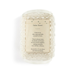 A white ceramic woven loaf basket with handles on the ends. The basket comes with a cream towel with an inspirational poem on it.