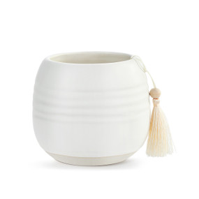A small round white ceramic cachepot with a cream tassel.