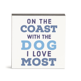 A small square white wall art with the saying "On the coast with the dog I love most".