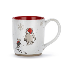 A white ceramic mug with a red interior and tan textured base. There is an image of Pooh and Piglet walking in the snow on the front.