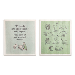 Two biodegradable dish cloths in green and light blue. One has illustrations of Eeyore and the other has an illustration of Christoper Robin attaching Eeyore's tail and the saying "Friends are like tails," said Eeyore. "You kind of get attached to them."