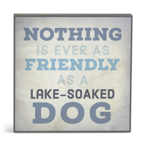 A square gray wall art with the saying "Nothing is ever as friendly as a lake-soaked dog".