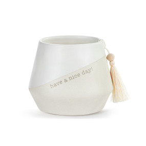 A small round white ceramic cachepot with "have a nice day!" on the front with a cream tassel.