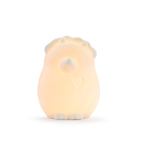 A ceramic dinosaur shaped night light displayed lit up.