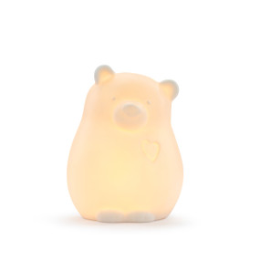 A ceramic bear shaped night light, displayed lit up.