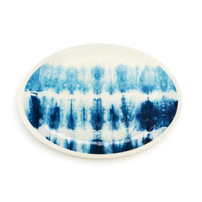 Top down view of a large blue and white oval melamine platter with a tie dye pattern.