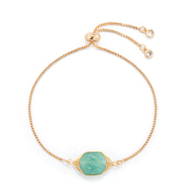 A gold chain adjustable bracelet with a green stone charm.