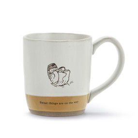 A white and brown ceramic mug with an illustration of Pooh eating honey and the saying "Sweet things are on the way" at the bottom.