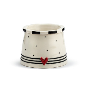 A cream stoneware dip chiller bowl with a raised red heart and black lines and dots.