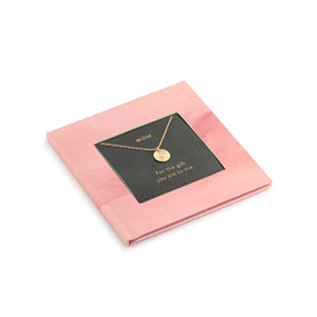 A small square pink book with inspirational content about moms. There is a gold chain necklace inside with a round charm.