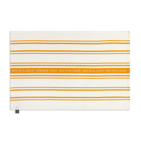 A cream and orange striped kitchen towel. The middle stripe says "Now We're Cookin'".