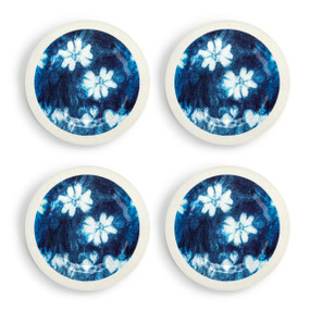 A set of four white melamine appetizer plates with a dark blue and white floral pattern.