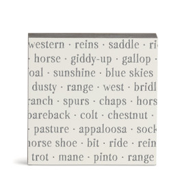 A white square wall art with words about western living on it.