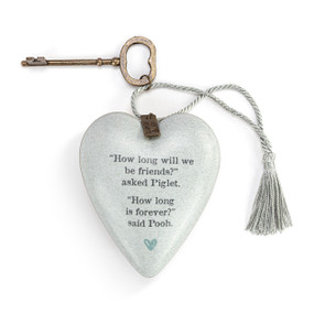 Heart shaped sculpture with a silver tassel and metal key attached. The heart has a light gray background and says "How long will we be friends?" asked Piglet. "How long is forever?" said Pooh.