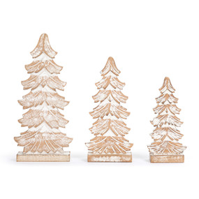 A set of three whitewashed flocked wood carved trees in various sizes.