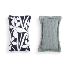 A set of two fabric kitchen sponges. On has large bold black and white floral artwork and the other is gray.