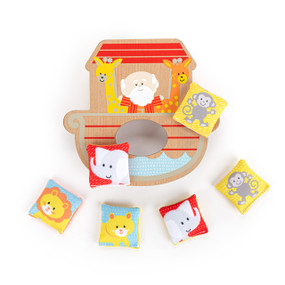 A Noah's Ark themed wood tabletop bean bag toss shaped like the ark, with Noah and two giraffes painted on the front. There are six beanbags included with different animals on them.