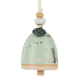 A mini light green bell with the word "believe" and an image of Pooh floating under a balloon. There are beads and a metal token at the top of the bell.