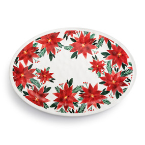 Top down view of a large white oval melamine platter with a red poinsettia pattern on the top.