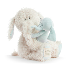 A fuzzy plush cream elephant holding a light blue baby plush elephant.