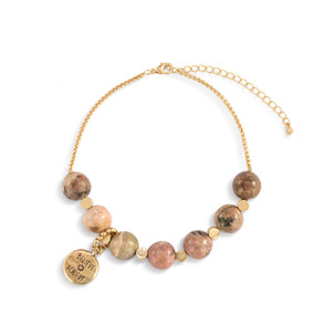 An adjustable gold chain bracelet with 7 pink and gold beads. There is a round gold charm that says "Believe Achieve" that can move between the seven beads.