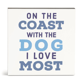 A square white wall art with the saying "On the coast with the dog I love most".