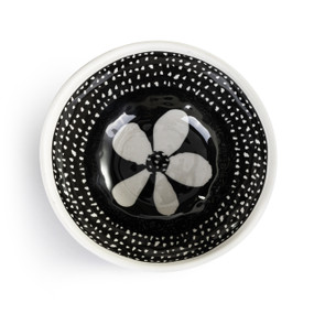 A black and white melamine dip bowl. The inside of the bowl is black with white dots and flower inside.
