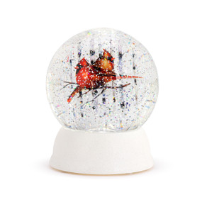 A lit snow globe with a white base and a watercolor image of a pair of cardinals inside.
