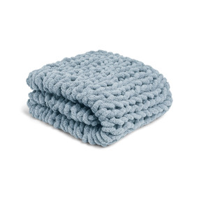 A light blue chunky knit blanket displayed folded.