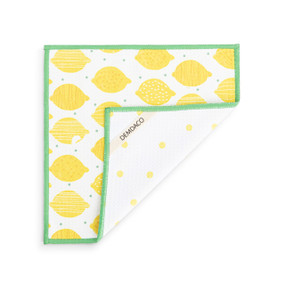A double sided square dish cloth that is white on one side with yellow lemon illustrations, displayed with a corner turned back.