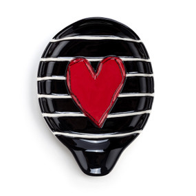 A black stoneware spoon rest with white stripes and a raised red heart.