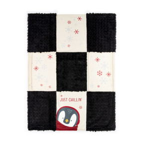A nine patch blanket made of black fuzzy squares and cream squares with red and white snowflakes. The bottom middle has an image of a penguin and the saying "Just Chillin'".