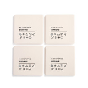 A set of four white ceramic coasters with the saying "RE: Out of Office Snowbound!" with a set of emoji images related to a winter vacation.