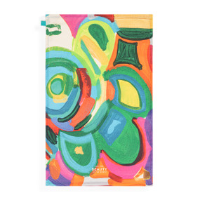 A tea towel with artwork inspired by ArtLifting artist Matthew Breedlove of a colorful abstract floral pattern that says "See the Beauty in the World" at the bottom.