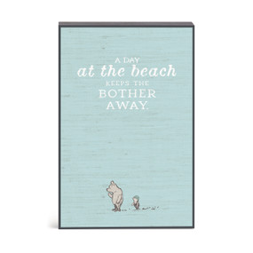 A blue wall art with an illustration of Pooh and Piglet and the saying "A day at the beach keeps the bother away."