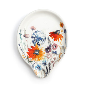 Top down view of a cream ceramic spoon rest with a watercolor image of colorful wildflowers.