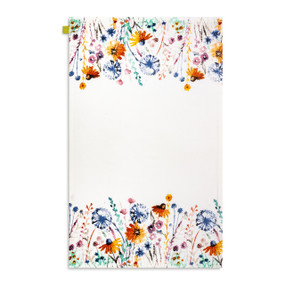 A white kitchen towel with illustrations of wildflowers displayed with the towel laid out flat.