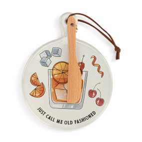 A round ceramic white mini serving board with an illustration of an old fashioned and the saying "Just Call Me Old Fashioned". The board has a small wood knife attached.