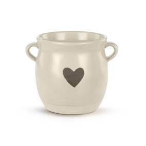 A cream ceramic planter with two small handles on the sides and a gray heart on the front.
