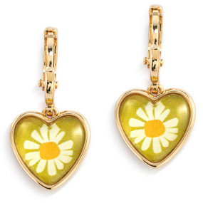 A pair of gold dangling earrings with a heart shaped charm and an illustration of a white daisy inside.