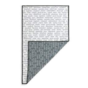 A rectangular double sided towel. One side is white with words about cleanliness and the other is gray with words about being dirty, displayed with the gray corner turned back.