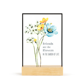A large rectangular suncatcher in a light wood base. The image is various flowers on stems and the saying "Friends are the Flowers in the garden of life".