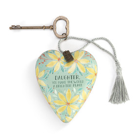 Heart shaped sculpture with a silver tassel and metal key attached. The heart has a light green background with yellow flowers and says "Daughter, You Make The World A Brighter Place".