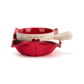A cream handled soup bowl with a red interior inside a red fabric cozy. The bowl says "made with love" with a red heart.