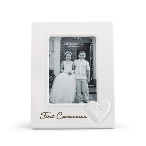 A vertical white ceramic 4x6 frame with a raised white heart with a cross in the middle at the lower right corner. The frame says "First Communion".