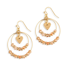A pair of multi hoop gold earrings with various gold beads on the hoops and a gold heart charm in the middle.