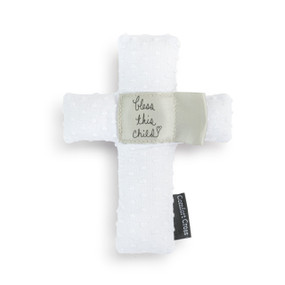 A white plush cross with the saying "bless this child" in the middle.