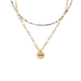 A layered necklace made of a gold chain with a round gold charm that says "Family" and a layer of brown, gray and cream small beads.