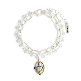 A silver chain and beaded bracelet with a silver sacred heart charm with a gold border.
