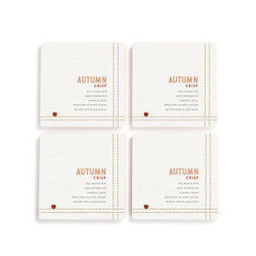 A set of four white square coasters with a basic recipe for an Autumn Crisp written in orange.